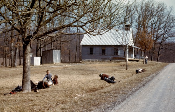 Children playing by road near school house
