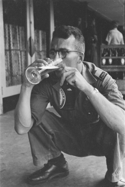 Man drinks a glass of beer and holds a beer bottle in his other hand; Date June 1947; Location Batavia, Indonesia, Jakarta, Dutch East Indies