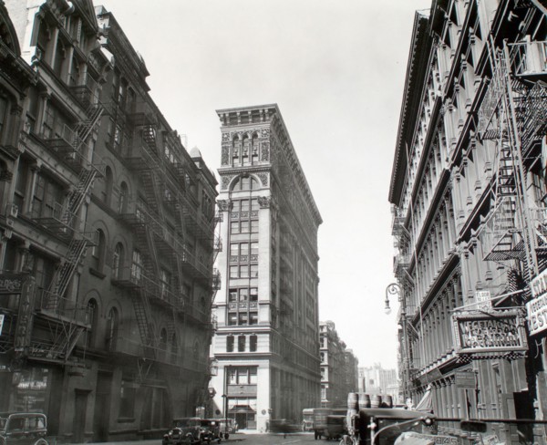 1930s New York City - Looking down Broadway, ornate Bank of Sicily Trust near center of image, sign for vegetarian restaurant, right, cars and trucks, Broadway near Broome Street, Manhattan ca. 1935
