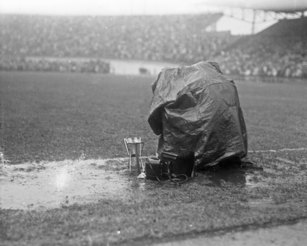 September 21, 1947 - Reporters covering a soccer match in Amsterdam take cover from the rain