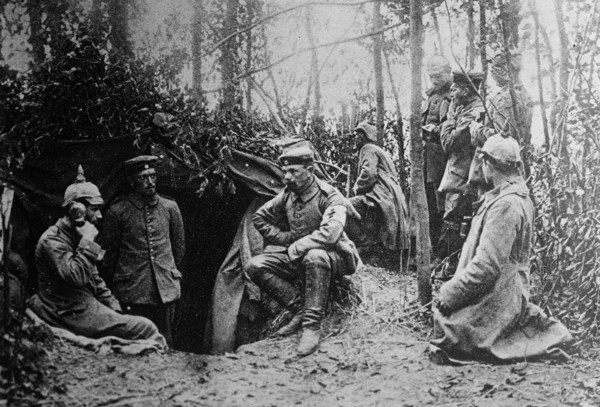 German soldiers in a dugout during World War I. One soldier is using a field telephone ca. 1914-1915