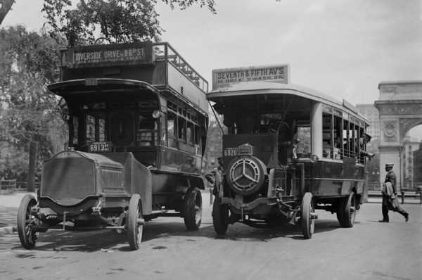 Buses on Fifth Avenue, New York City, including one made by De Dion-Bouton of France (right). The Washington Square Arch is in the background ca. 1913