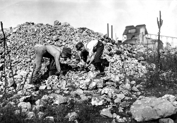 Two young boys collecting rocks, 1912