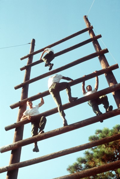 1978 - Soldiers climb a large wooden ladder while on an obstacle course.