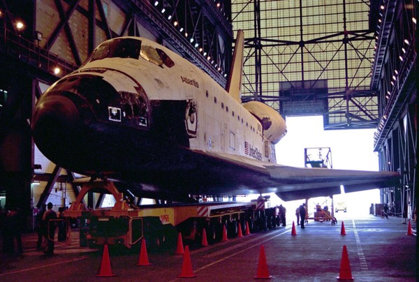 Carried atop an orbiter transporter, the Space Shuttle orbiter Atlantis rolls into the transfer aisle of the Vehicle Assembly Building (VAB) ca. 1997