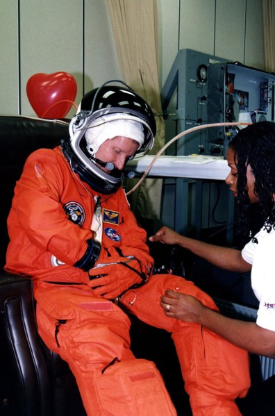 STS-82 Mission Specialist Steven A. Hawley makes some final adjustments to his launch and entry suit with assistance from a suit technician in the Operations and Checkout Building ca. 1997