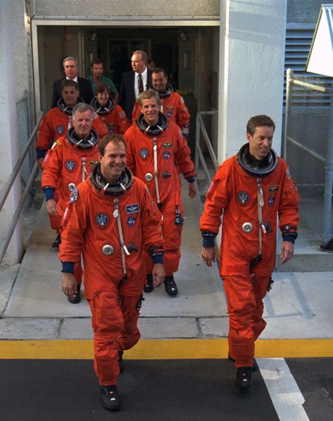 STS-86 Commander James Wetherbee, in foreground at right, leads the way as the next Space Shuttle crew does a practice walkout from the Operations and Checkout Building ca. 1997
