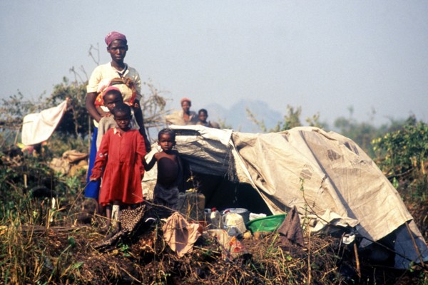1994 - A Rwandan family pose in front of their makeshift home