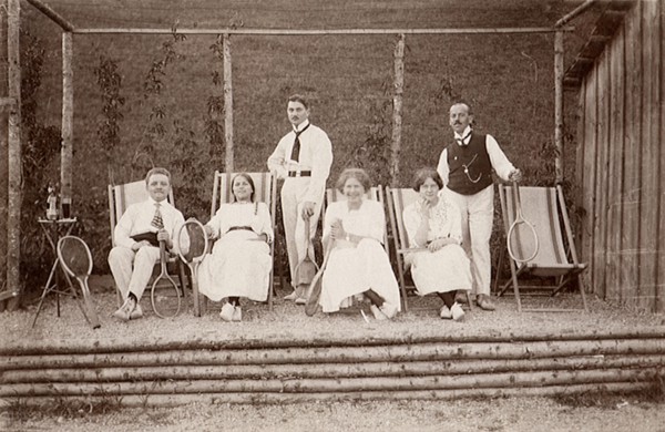 Three tennis couples posing on lounge chairs.