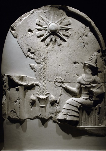Upper section of a stele with depiction of a libation scene before a seated god