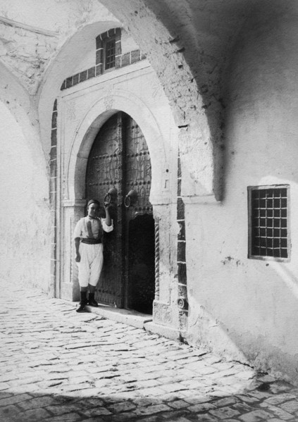 afrique, tunisie, île de djerba, un garçon à l'entrée de sa maison, 1910 1920