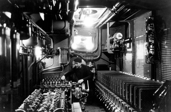un conducteur de train vérifie les moteurs électriques d'un train en marche, 1964