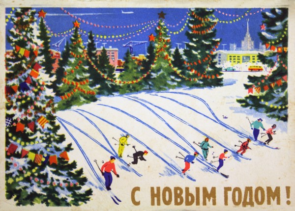 Skiers descend from a mountain surrounded by Christmas trees.