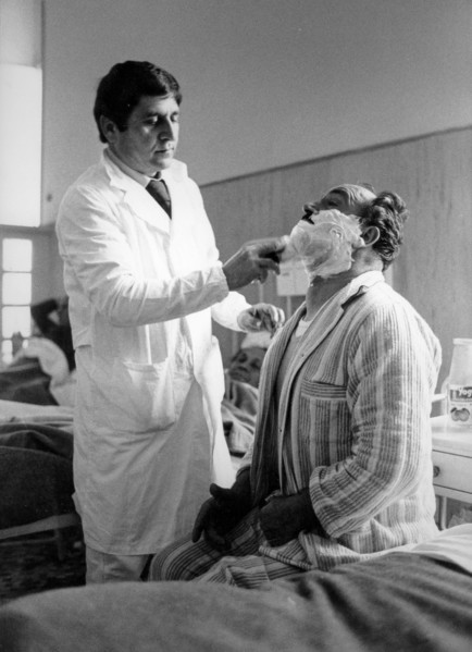 Barber shaves a patient of the San Giovanni hospital, Rome, 70s