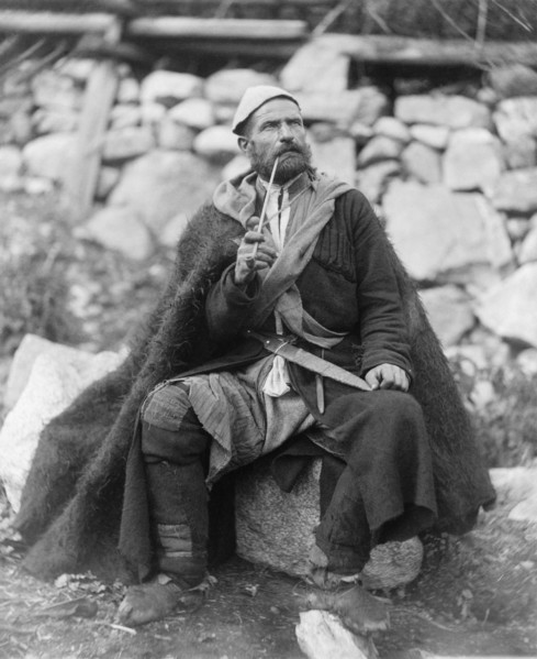 Old peasant with dagger and long smoking pipe