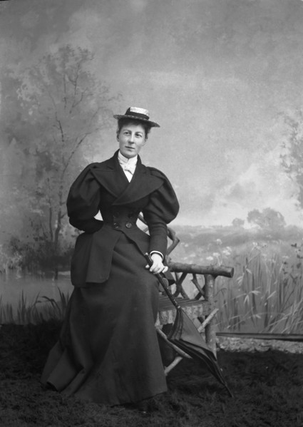 A lady with umbrella with hand painted backdrop.
