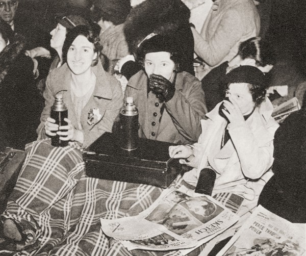 Three women have an early morning cup of tea in Piccadilly Circus.