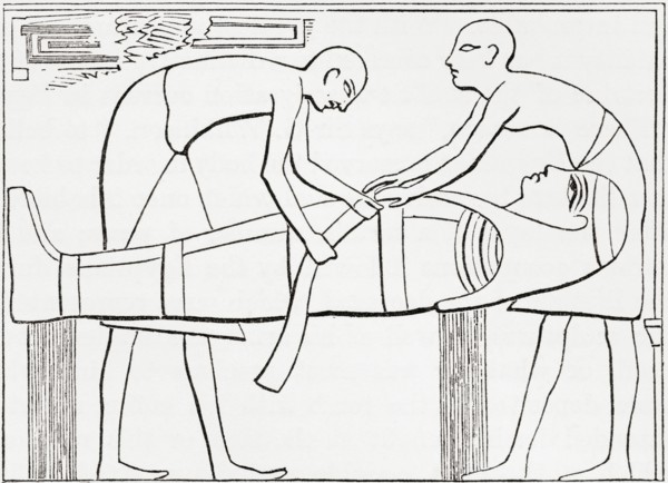 Ancient Egyptians swathing or wrapping bandages round a mummy.