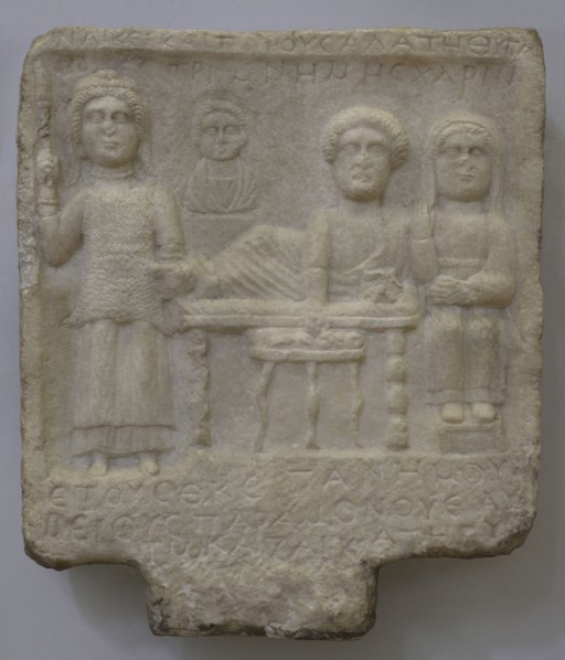 Goddess Bendis and a family group: bust of a child and feasting husband and wife. Inscription in
