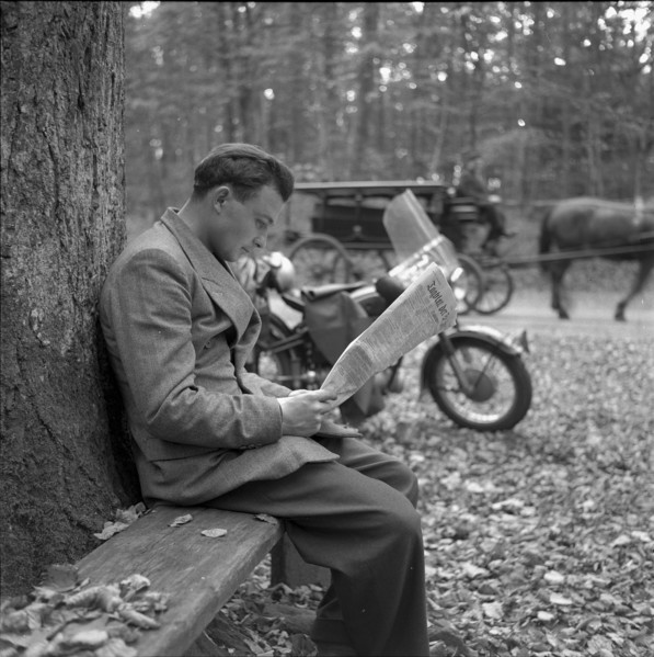 Man reading the newspaper in the forest, around 1960