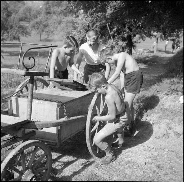 Children transporting peat briquettes; 1940