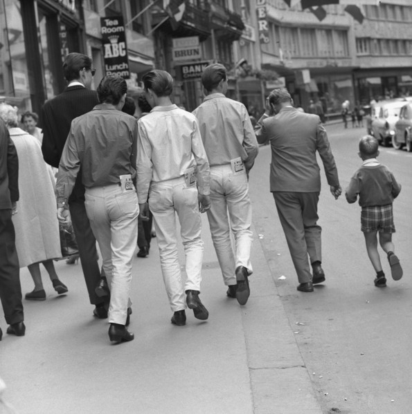 Young people looking in their pockets, 1960