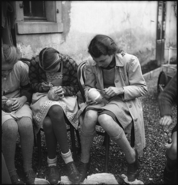 Preparations for Räbeliechtli procession, girls carving in turnips, 1945.