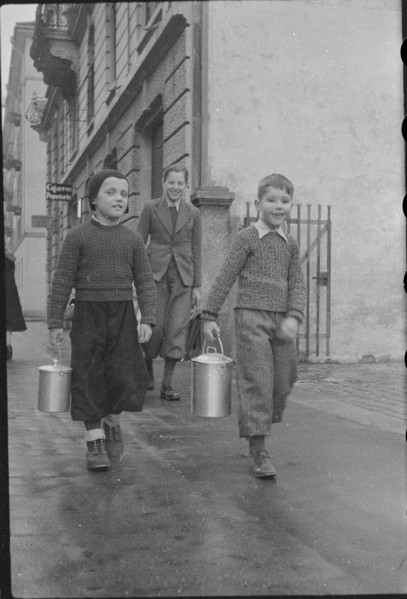 Children bringing home soup from public kitchen; 1945.
