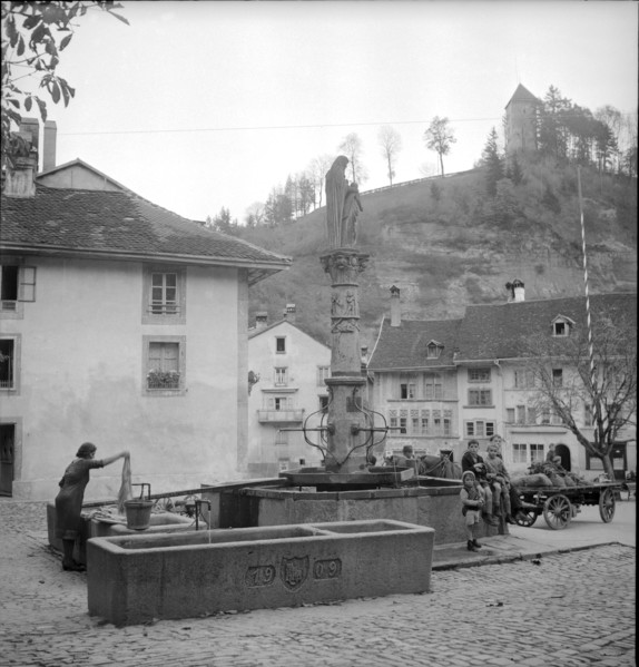 Fribourg; laundress at St. Anne fountain; 1945.
