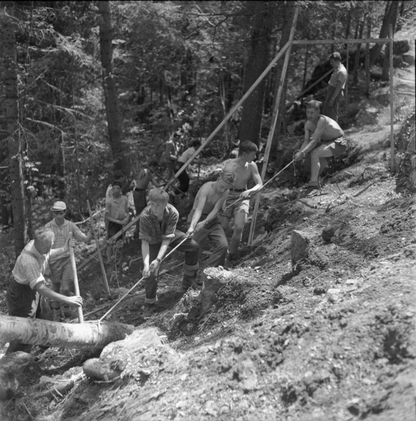 Isenfluh, volunteers building access road to mountain village; 1959.