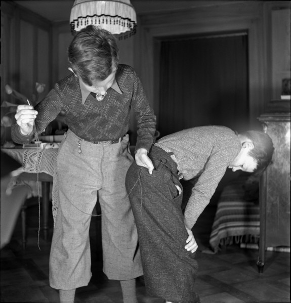 Boy mending his brother's trousers on Mother's Day, 1941.