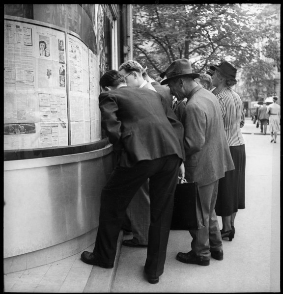 People reading advance sheets of Neue Zurcher Zeitung; 1939.