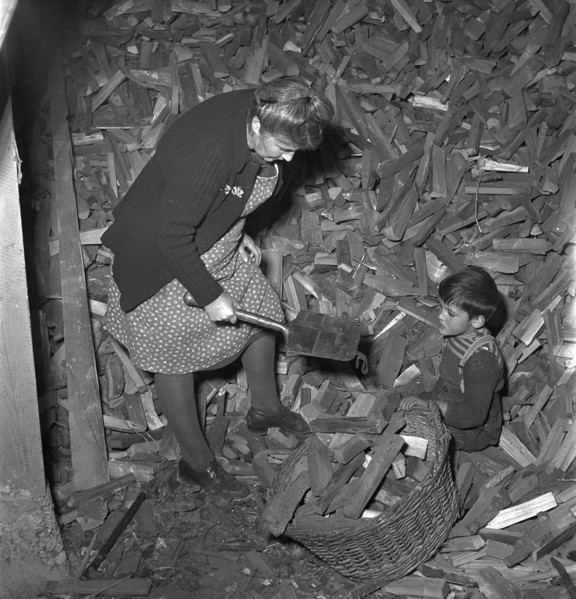 Woman finding lost army shovel in firewood storeroom 1949.