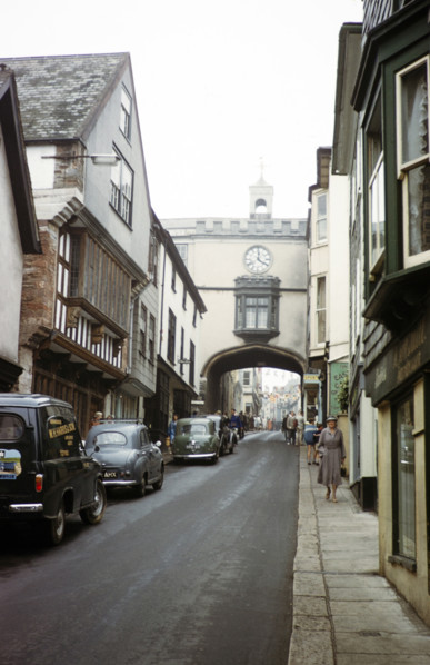 Cars and people High Street, East Gate arch gateway, Totnes, Devon, England, UK early 1960s.