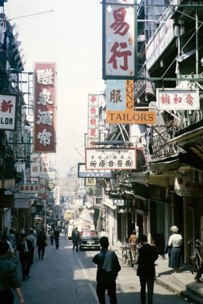 Busy street of shops and signs in English and Mandarin including for Tai Cheong Tailors, Wellington