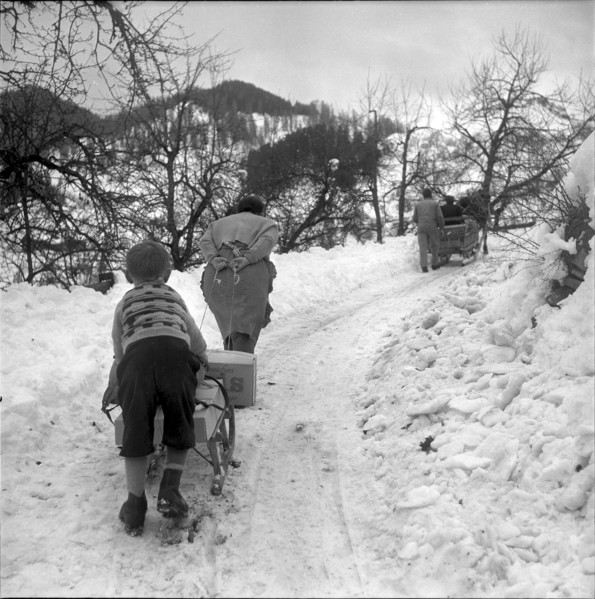A woman and a boy carying parcels on a sledge 1953