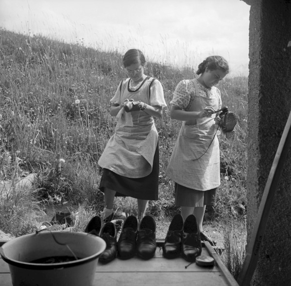 Cleaning shoes at school for household in Casoja, 1940