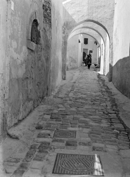Archways in narrow alleyway street in Medina old town area.