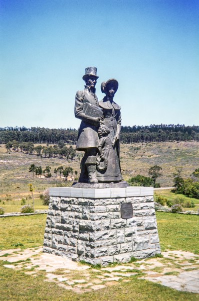 bronze statue of a Victorian-era settler family (a man, woman, and child) at the 1820 Settlers National Monument in Grahamstown (now Makhanda), South Africa.