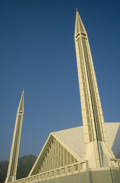 PAKISTAN, Islamabad, "Faisal mosque.  Detail of white rooftop and minarets against blue sky.