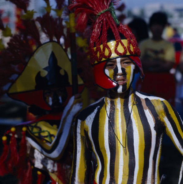 PHILIPPINES, Luzon, Manila, Boy at Ati-Atihan  festival with striped painted body and wearing a red