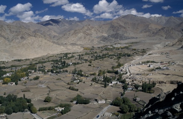 INDIA, Ladakh Region, View over valley with scattered houses and cultivated land surrounded by
