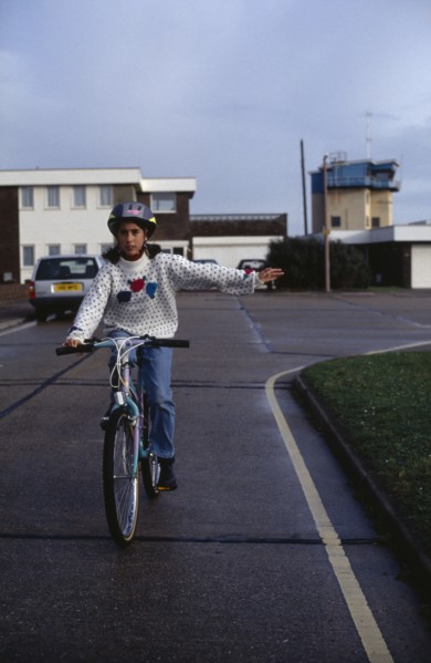 10013304 SPORT  Cyclists Girl wearing safety head gear  riding bike giving a hand signal.