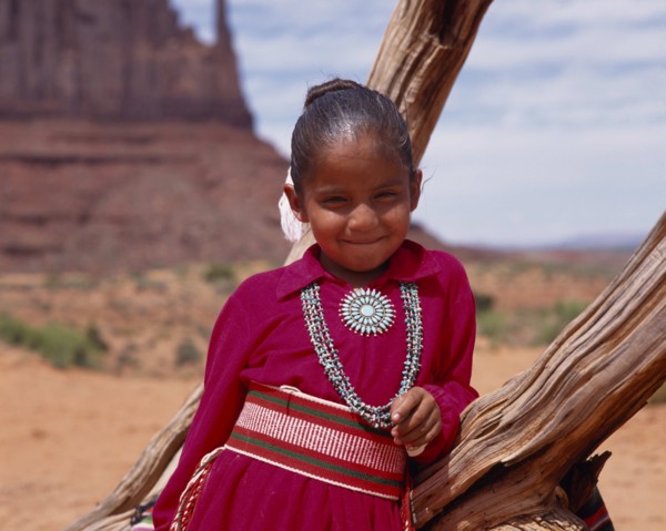 USA, Arizona, Monument Valley, Portrait of Navejo girl wearing a red dress and turquoise necklace