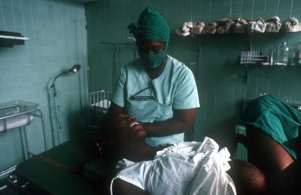 CUBA, Havana, Pregant woman in advanced labour being attended by nurse in the delivery suite