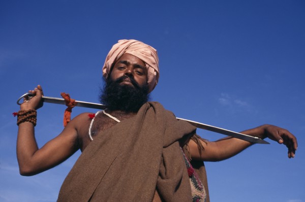 INDIA, Delhi , SIkh man holding Holy Kirpan Sword for the defence of the weak.  Three-quarter view