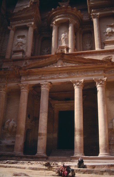 JORDAN, Petra, The Treasury entrance with camel sitting in foreground