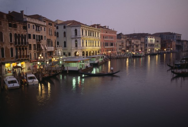ITALY, Veneto, Venice, The Grand Canal at night with lights reflected in the water. Moored gondolas