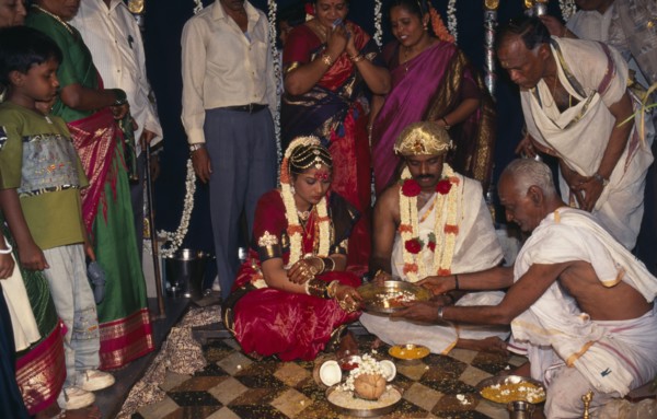 INDIA, Bangalore , Hindu Wedding, People standing around sitting couple wearing traditional wedding