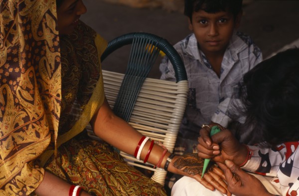 INDIA, Delhi , Applying henna to hands in preparation for wedding.